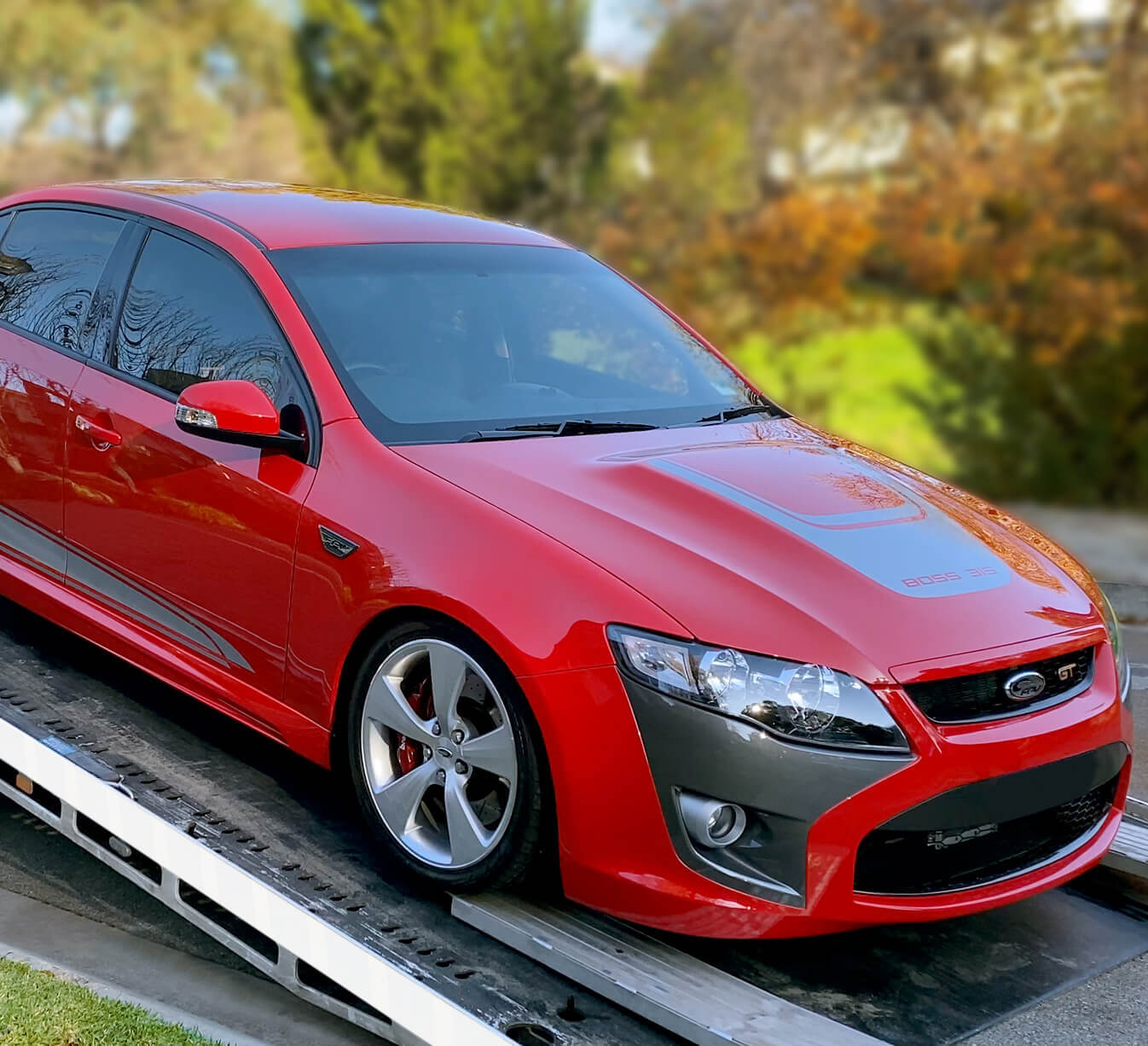 Maxi Equipment Hire Tow Truck Adelaide page photo of their tilt tray truck. photo of their tilt tray truck with a red Ford Falcon GT being loaded onto the truck.